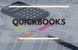 The word QuickBooks super imposed over papers and calculator