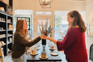 Two women holding a vase over a countertop