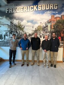 Group of men standing in front of a mural.