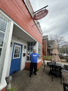 Man standing in front of restaurant.