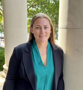 Woman leaning against column.